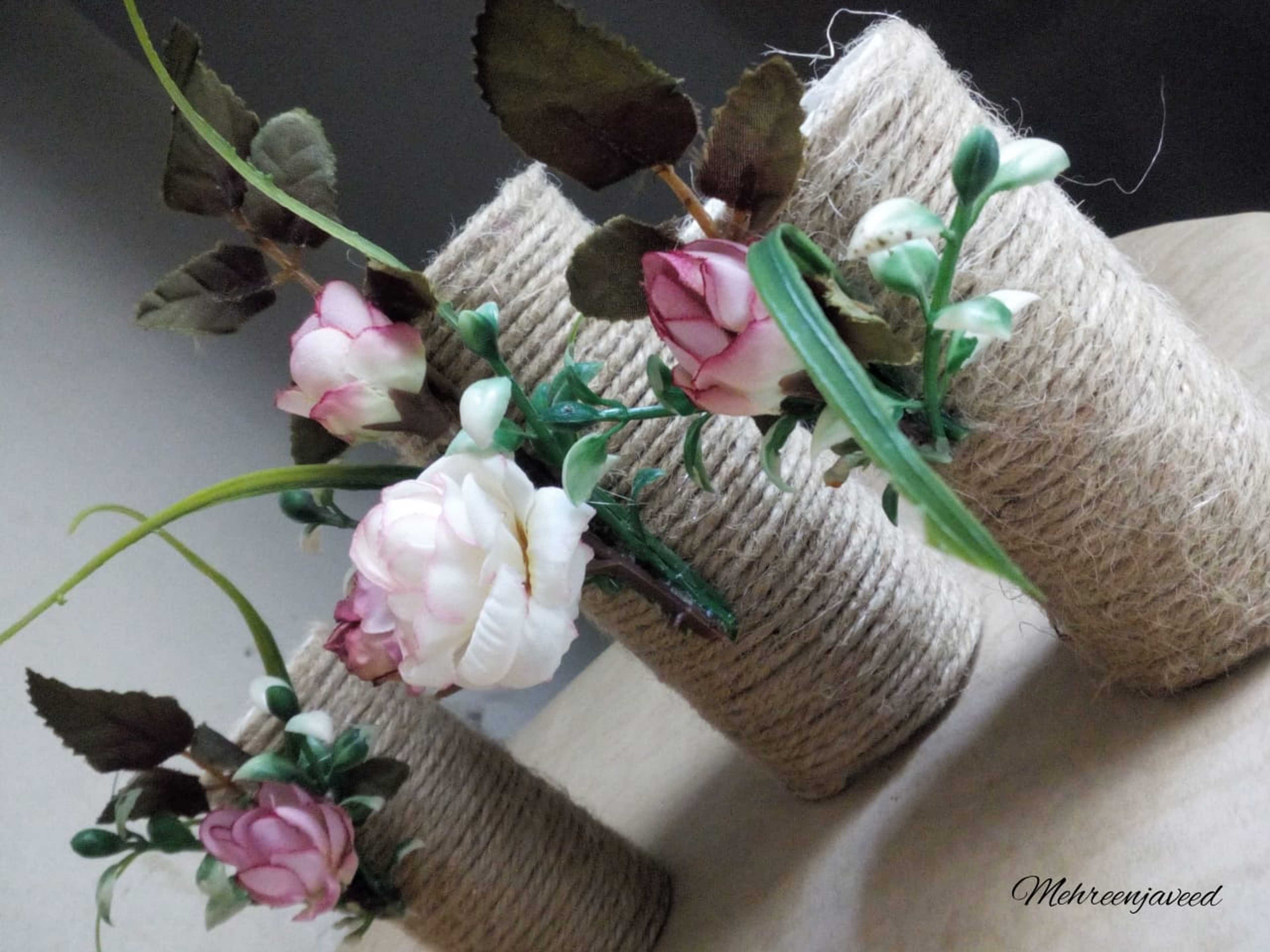 Flowers vase from glass bottle using rope thread
